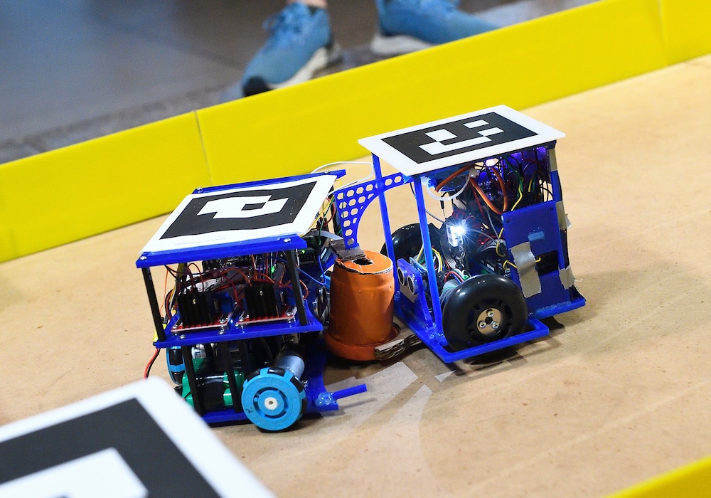 Two mechatronic robots fighting for a hockey puck in an arena.